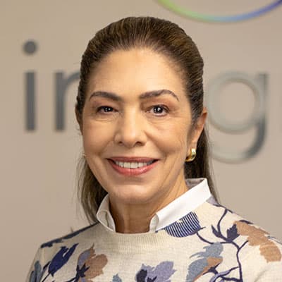 Mulher com suéter floral sorrindo.